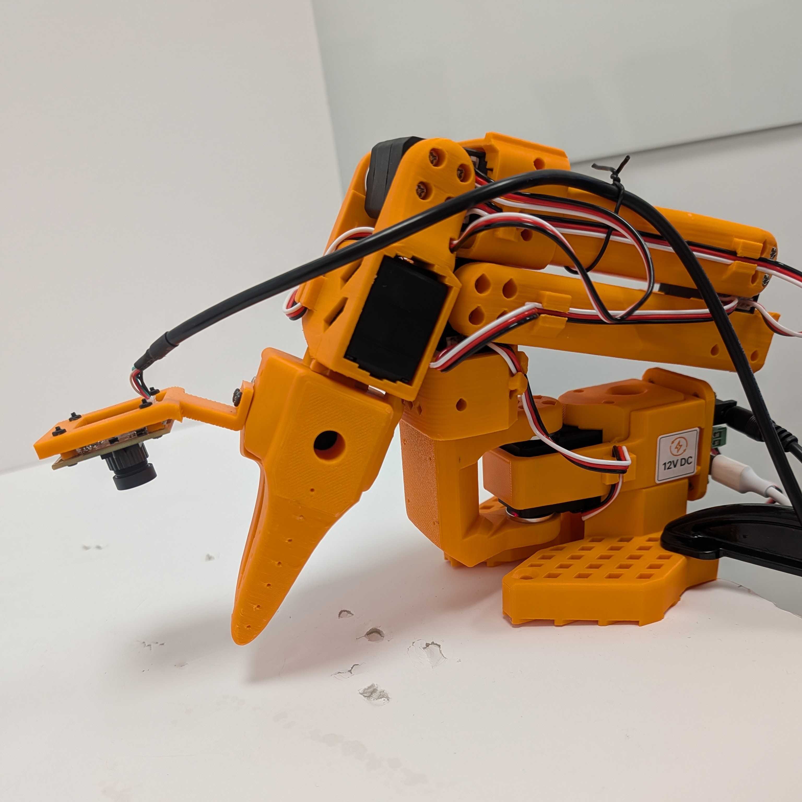 SO-101 follower arm Image Alt Text:SO-101 follower arm with its task gripper and wrist-mounted camera. The follower mirrors demonstrations during recording and is the arm controlled by the fine-tuned model.