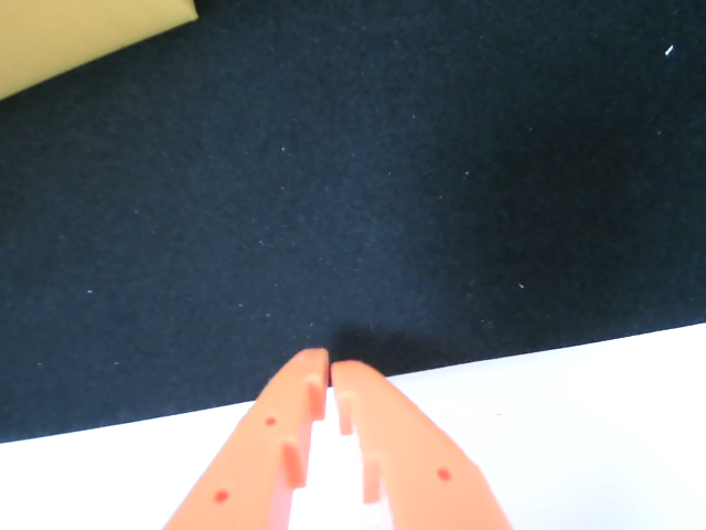 Gripper camera view Image Alt Text:LeRobot camera-discovery frame showing the orange gripper tips and pickup surface. Use this view for the <code>gripper_cam</code> role.