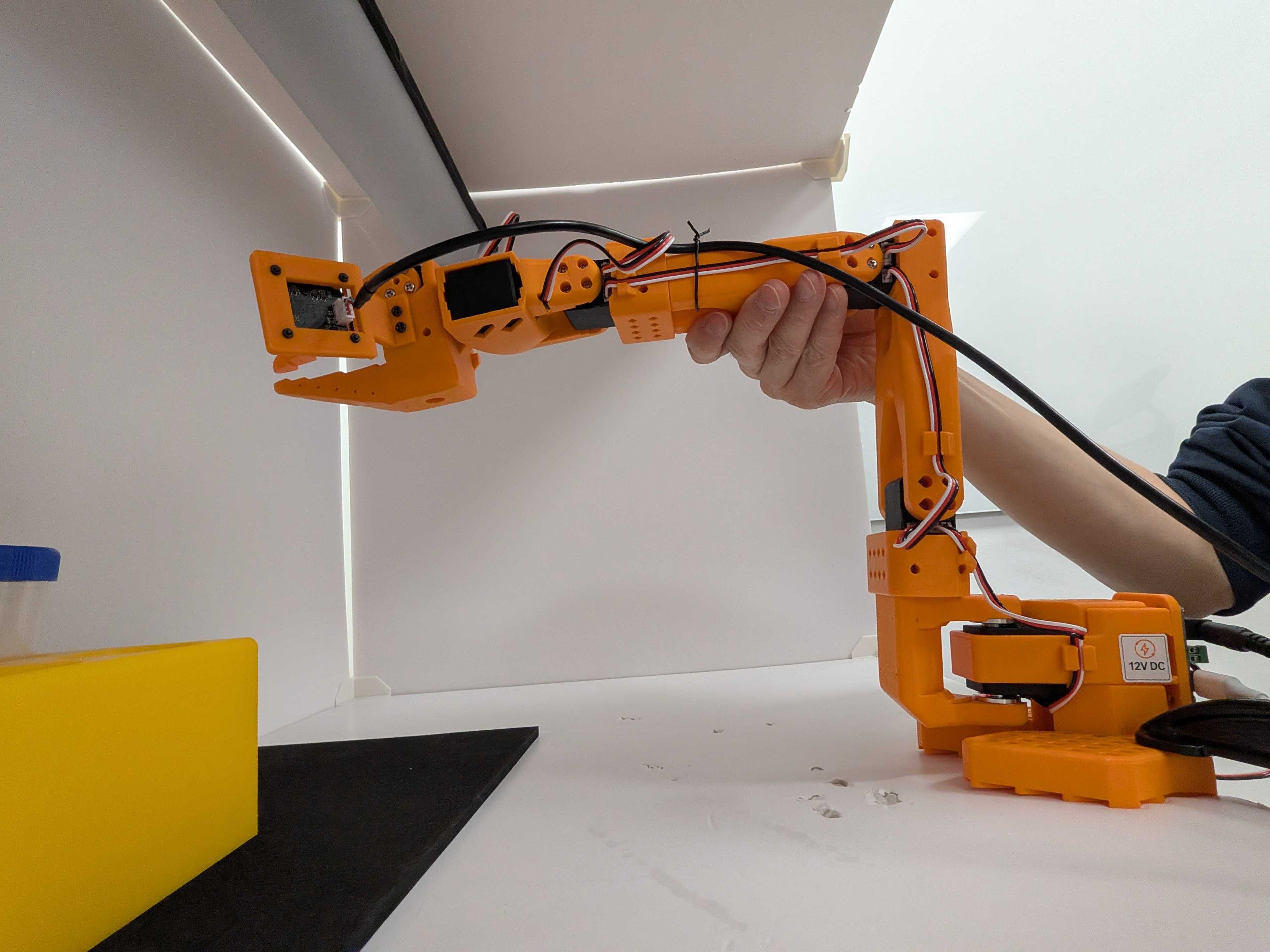 Image Alt Text:Follower SO-101 supported in the middle-range starting pose before calibration begins. The shoulder, elbow, wrist, and gripper all have room to move in both directions.