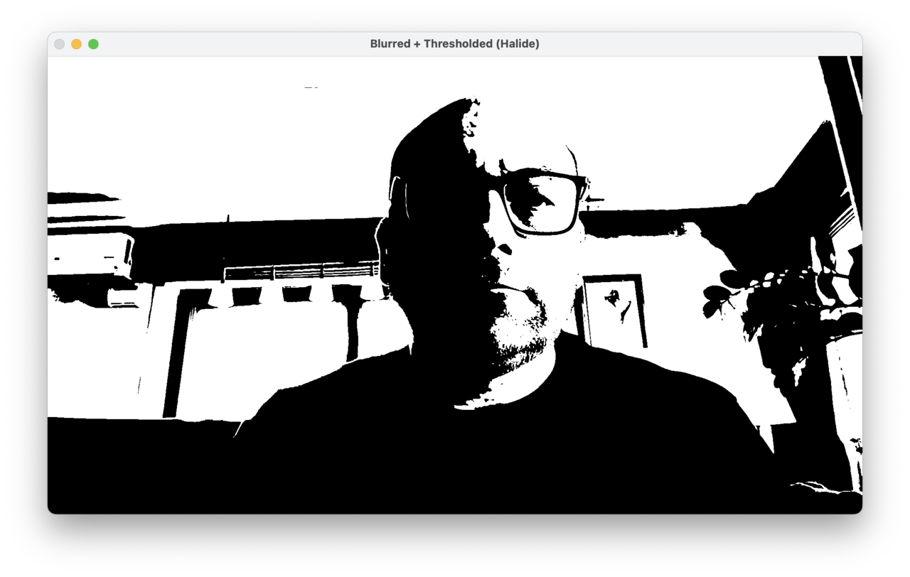 Image Alt Text:A camera viewport window titled Processing Workflow displaying a real-time binary threshold output from a webcam feed. The image shows a person&rsquo;s face and shoulders rendered in stark black and white, where bright areas above the threshold value appear white and darker areas appear black, creating a high-contrast silhouette effect that emphasizes edges and prominent features.